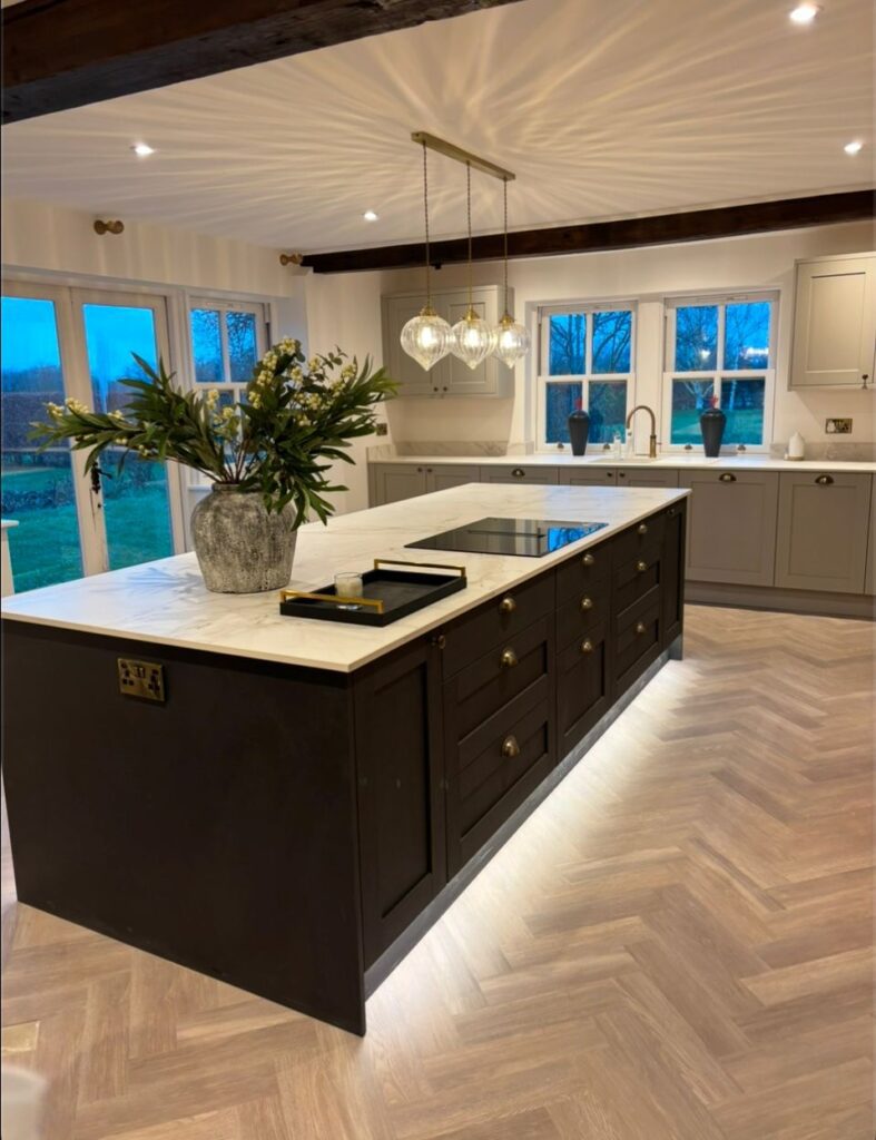 Kitchen setting with an island surrounded by Invictus Maximus plank flooring.