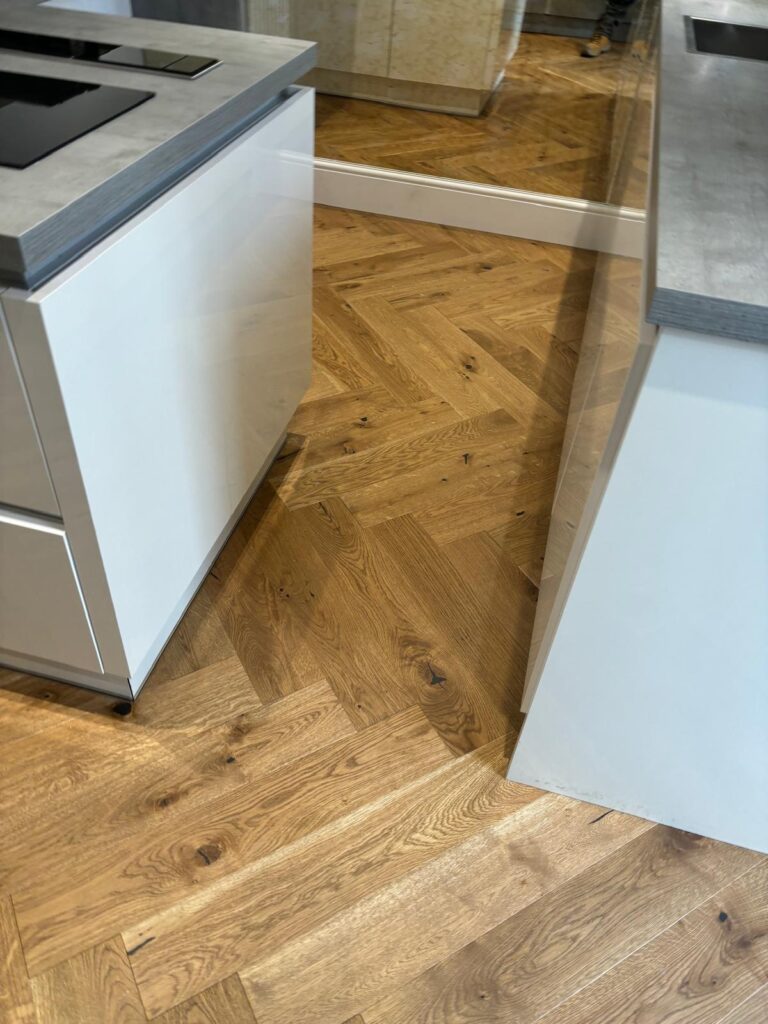 Herringbone wood flooring across the kitchen.