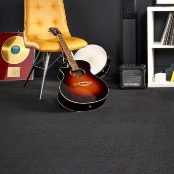 Bedroom setting with black carpet flooring.