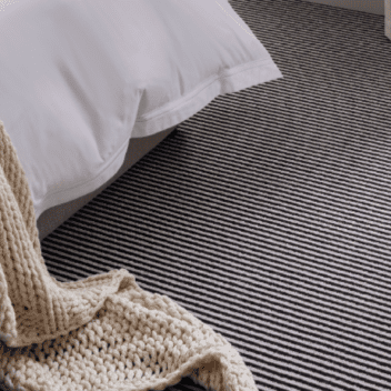 Room setting with bedroom and striped carpet